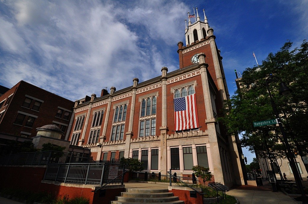 Manchester City Hall, a stone building with a clock tower, on Elm Street in Manchester, New Hampshire