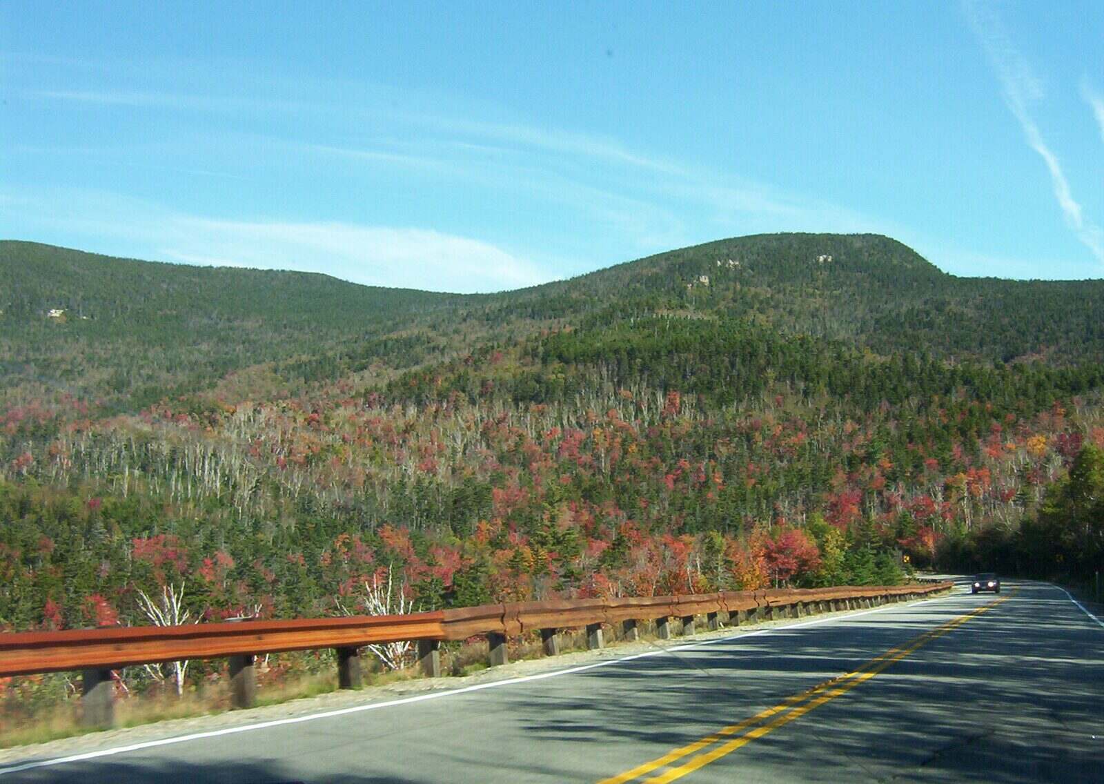 Two-lane Kancamagus Highway curving toward autumn mountains