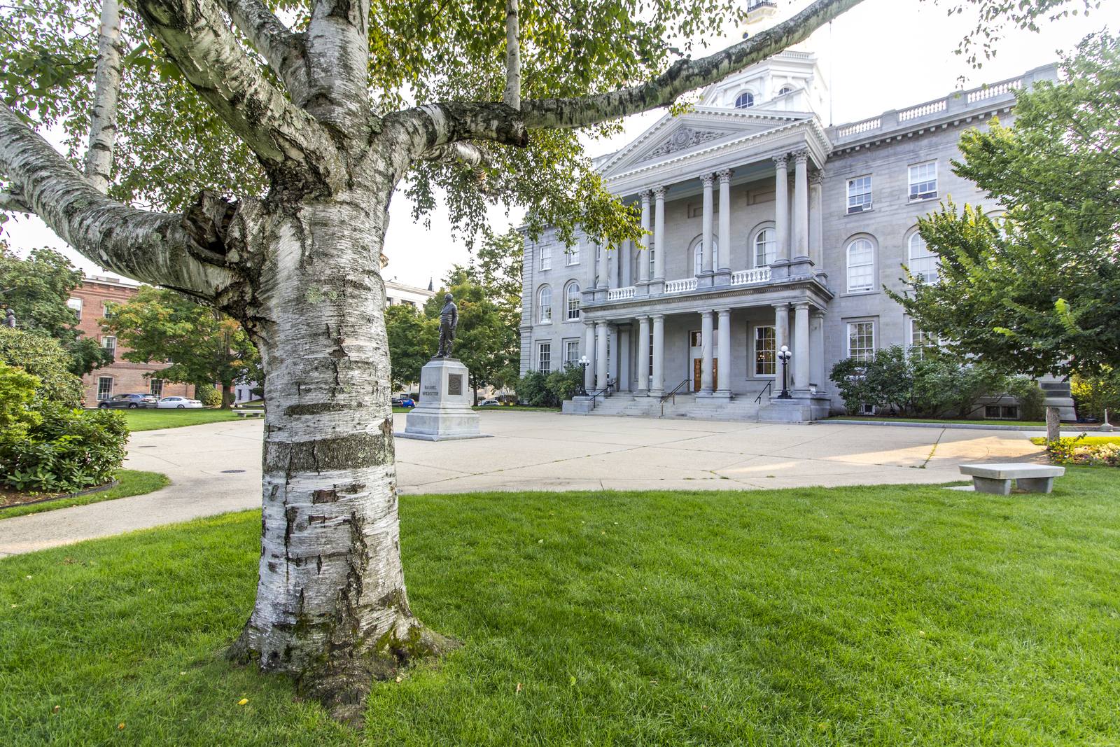The New Hampshire State House in Concord, a granite building with a gold dome and a columned entrance
