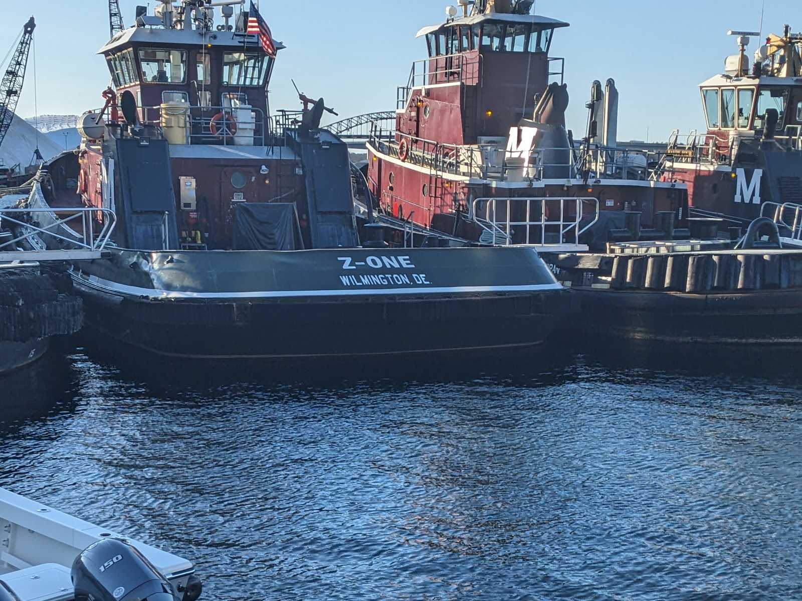 Tugboats tied up in Portsmouth harbor with the I-95 bridge in the distance