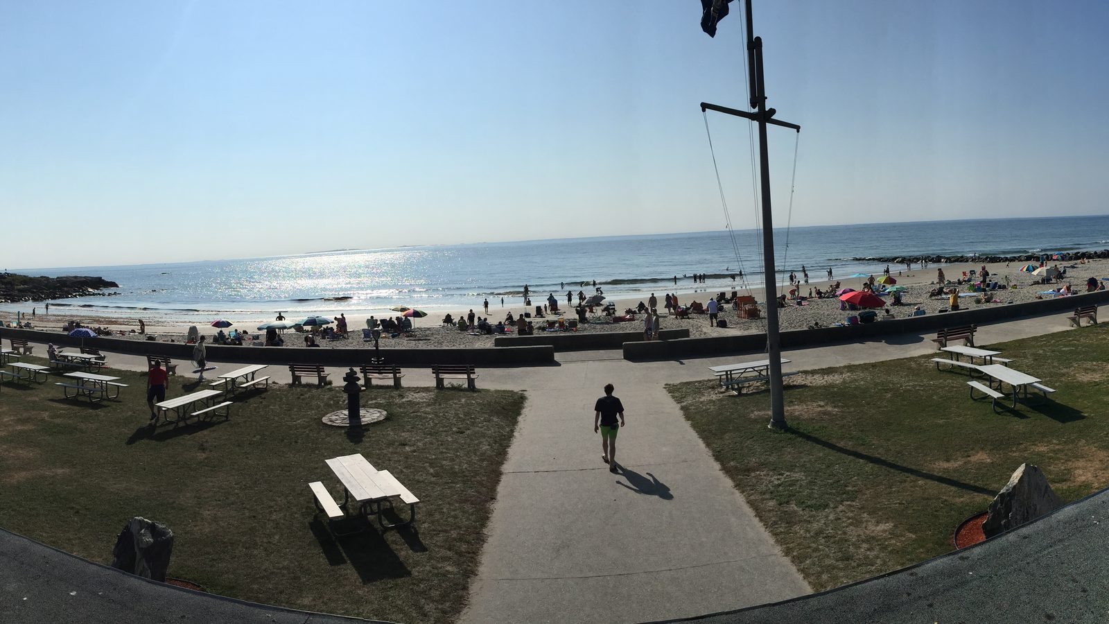 Picnic tables and a crowded beach looking toward the Isles of Shoals at Wallis Sands